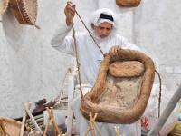 An upholsterer weaving a bassinet (SPA).