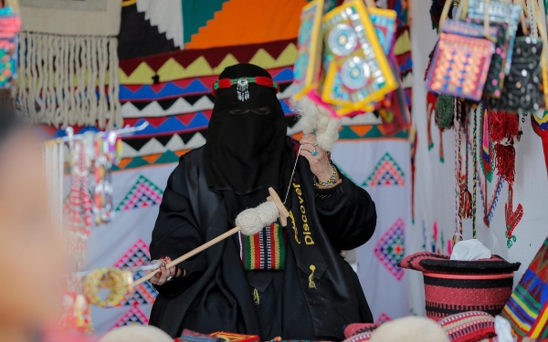 Image of a woman practicing al-Sadu art in a festival. (SPA)