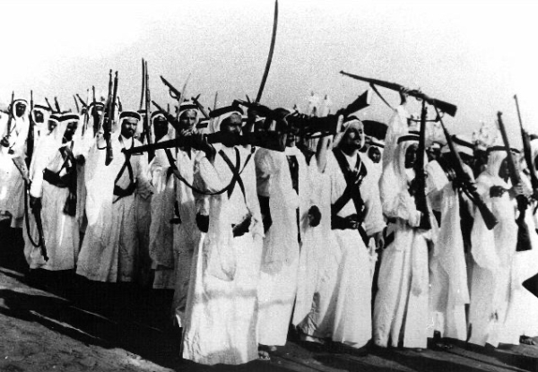 An old picture showing the carrying of rifles during a Saudi Ardah performance. King Abdulaziz Foundation for Research and Archives (Darah)