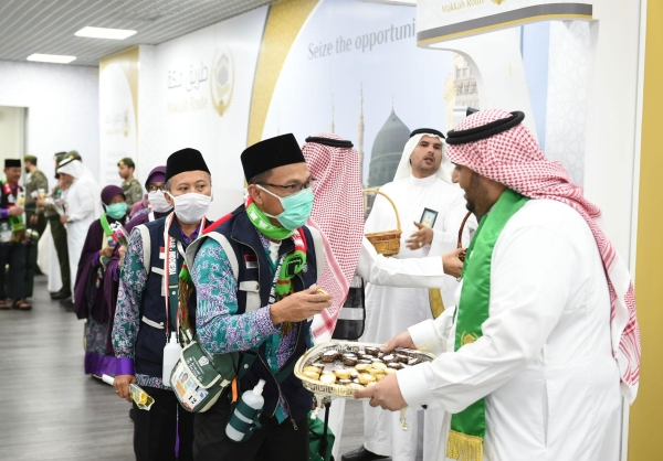 Welcoming and saying goodbye to pilgrims with candy and flowers within Makkah Route Initiative (SPA).