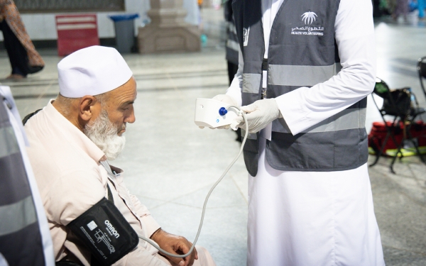 A volunteer providing healthcare to the visitors of the Holy Mosque. Efforts-of-the-health-volunteering-team