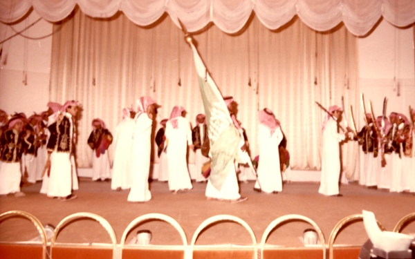 A picture of a group of students performing one of <i>Alardah Alnajdiyah</i> segments on stage in front of Abdulaziz Al-Khowaiter, Minister of Education, in 1982. (Darah)