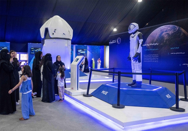 Visitors learning about the official uniforms of astronauts at the Saudi Towards Space exhibition (SPA).