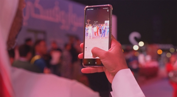 A visitor taking a photo in one of the entertainment festivals in the Kingdom. (Saudipedia)