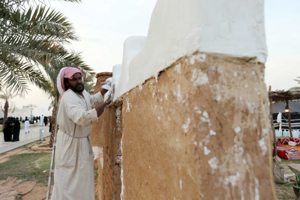 A craftsman applying gypsum on a wall of a traditional building. (Saudipedia)