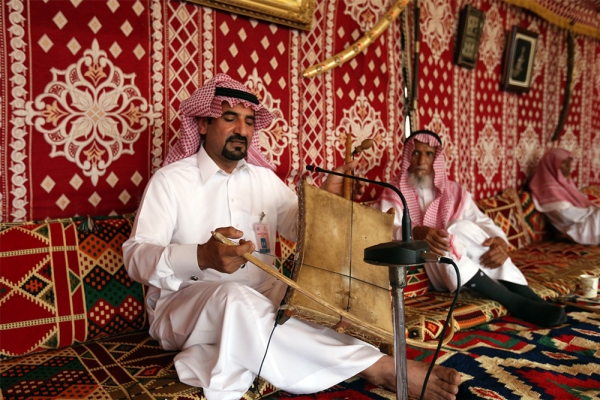 An artist playing the <i>Rebab</i>, a traditional musical instrument. (Saudipedia)
