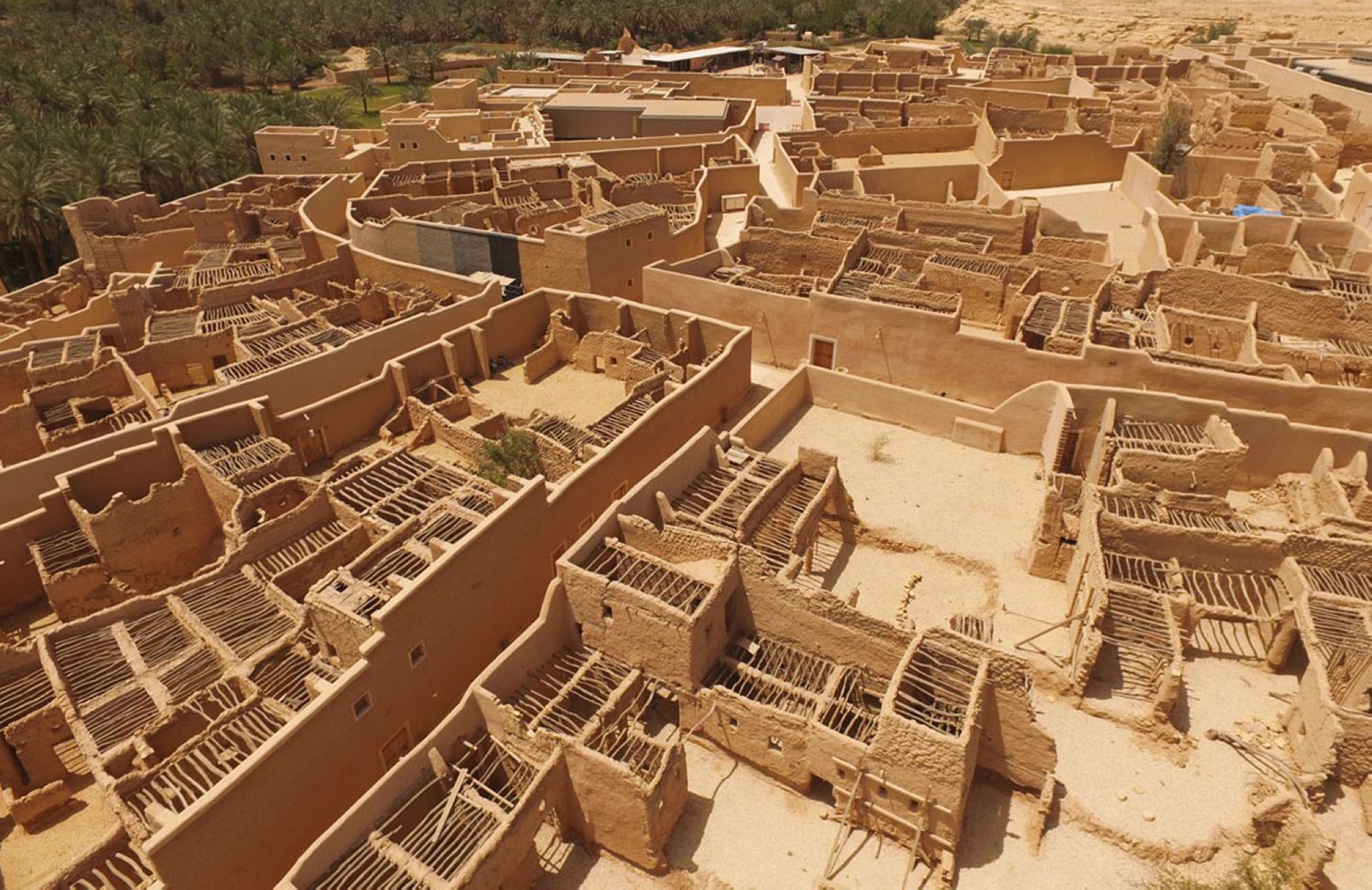 An aerial view of at-Turaif District, showcasing the mud-brick houses surrounded by palm trees. (King Abdulaziz Foundation for Research and Archives (Darah))