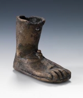 An ancient artifact made of bronze, shaped as a human foot and leg. (Saudi Commission for Tourism and Antiquities)