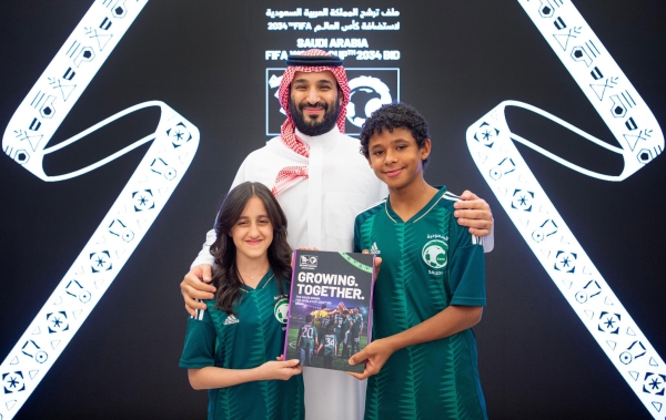 ولي العهد مع طفلين قبل مشاركتهما في تقديم ملف ترشح السعودية لاستضافة كأس العالم 2034. (الاتحاد السعودي لكرة القدم)