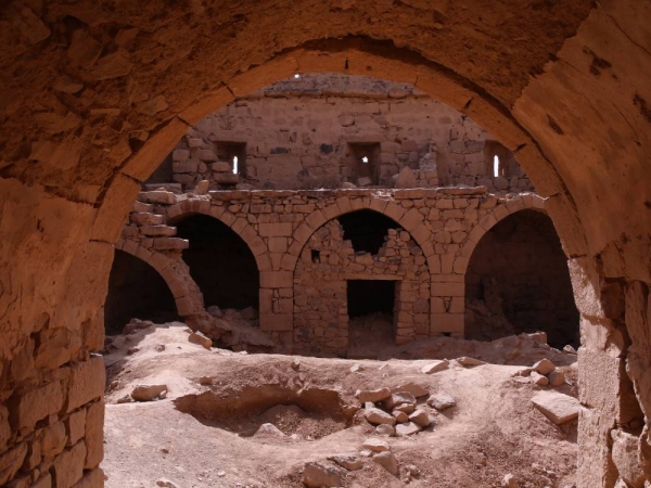 صورة من داخل قلعة المعظَّم يظهر فيها أحد المداخل المقوسة والساحة الداخلية. (دارة الملك عبدالعزيز)