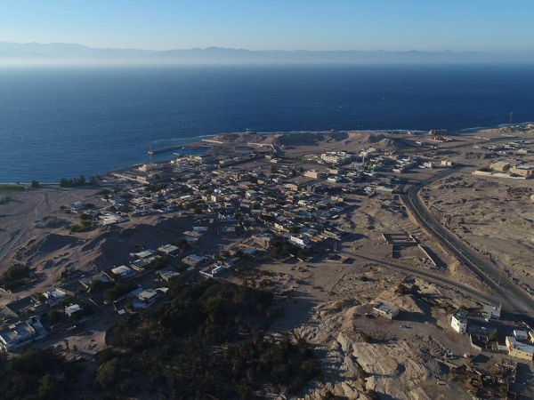 صورة جوية لمدينة مقنا تظهر فيها البيوت السكانية بالقرب من الشاطئ على البحر الأحمر. (دارة الملك عبدالعزيز)