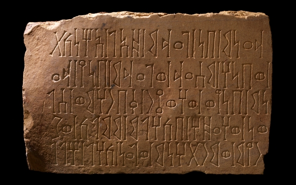 لوح حجري يحتوي على نقوشات أثرية بقرية الفاو. (وزارة الثقافة)
