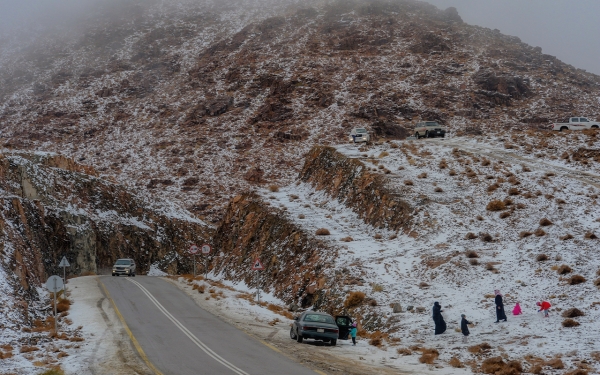أسرة تستمتع بالثلوج فوق جبل اللوز بمنطقة تبوك. (وزارة الثقافة)