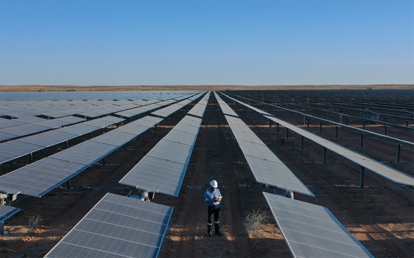 أحد المهندسين وسط ألواح الطاقة الشمسية في محطة سكاكا للطاقة الشمسية شمالي السعودية. (المركز الإعلامي لرؤية 2030)