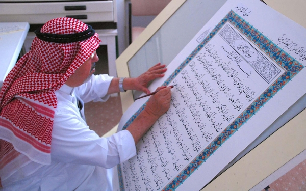 الخطاط عثمان طه يكتب المصحف الشريف في مجمع الملك فهد لطباعة المصحف الشريف. (واس)