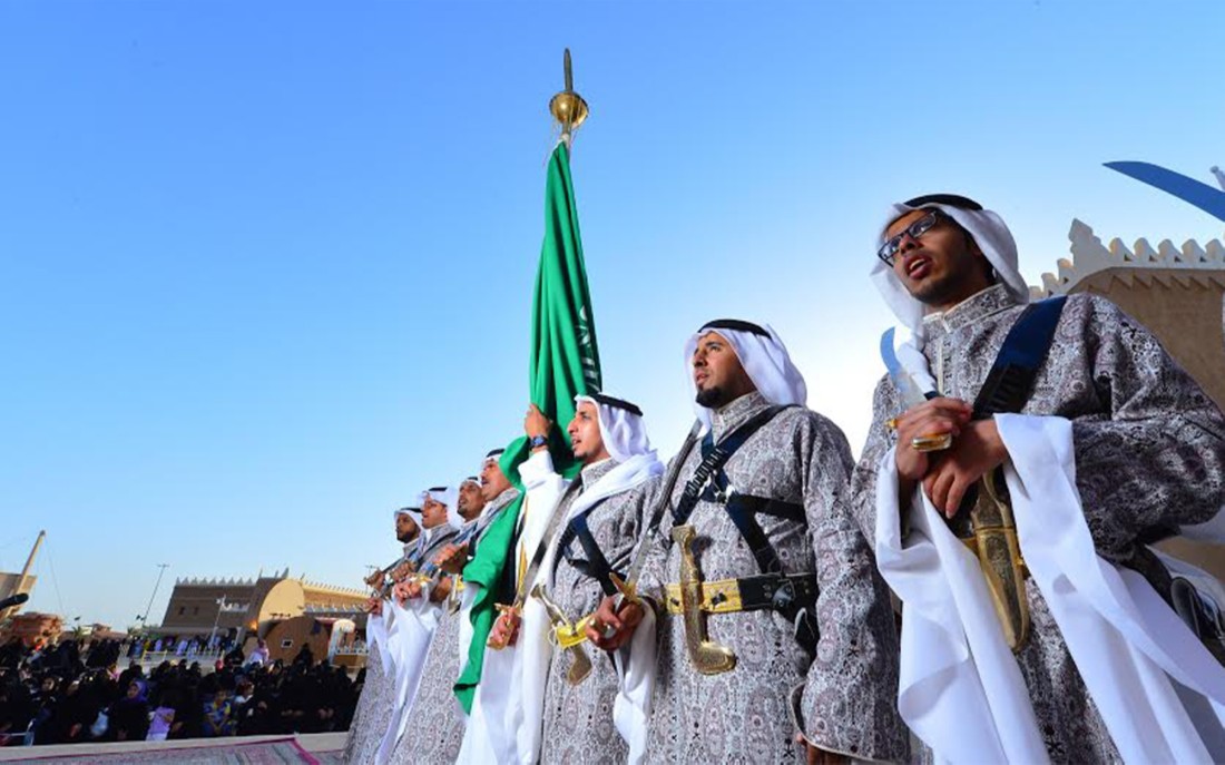مشهد يوضح حمل السيوف في العرضة السعودية. (دارة الملك عبدالعزيز)
