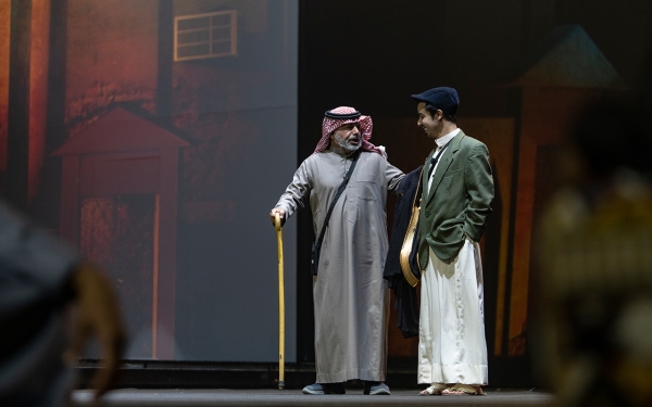 صورة لأحد العروض المسرحية يظهر فيه ممثلون يؤدون أدوارهم. (دارة الملك عبدالعزيز)