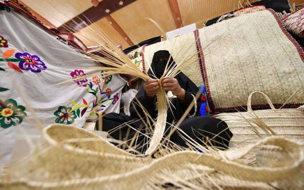 مسنة تقوم بصناعة الخوص في مهرجان الجنادرية. (واس)