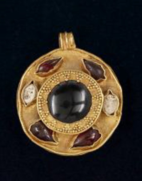 حلية دائرية مصنوعة من الذهب ومرصعة بالياقوت من حضارة عين جاوان. (الهيئة العامة للسياحة والآثار)