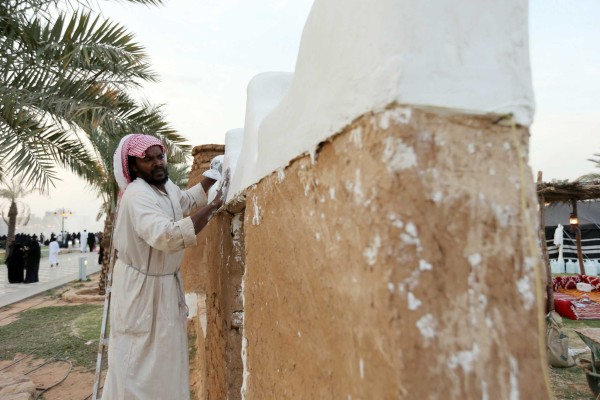 حرفي يضع الجص على جدار بناء شعبي. (سعوديبيديا)

