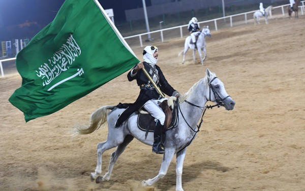 أحد الفرسان يحمل الراية السعودية خلال أحد العروض الاستعراضية. (واس)