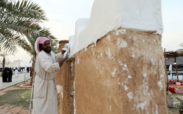 بنّاء يعمل على تكسية "عرائس السماء" بالجص. (سعوديبيديا)