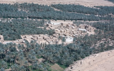 صورة جوية للدرعية عاصمة الدولة السعودية الأولى ومنازلها الطينية ومزارع النخيل. أنجلو بيشا. (دارة الملك عبدالعزيز)