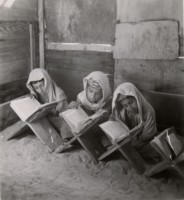أحد الكتاتيب يظهر فيه طلاب صغار أثناء قراءة القرآن. (دارة الملك عبدالعزيز)