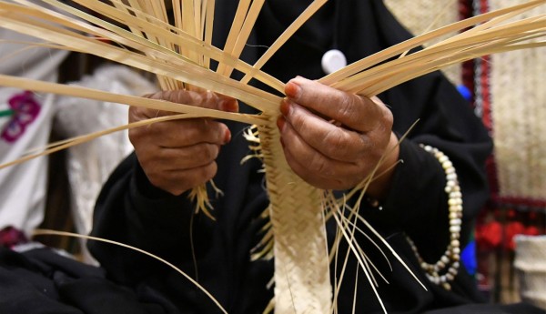 حرفية تصنع منتجًا من الخوص. (واس)
