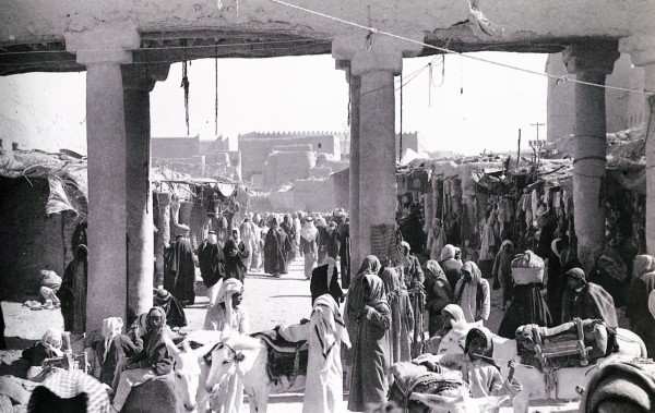 سوق العلف إحدى أسواق الرياض تظهر ساحاتها ممتلئة بالمرتادين والباعة كما تظهر بعض الدكاكين الصغيرة عام 1370هـ/1950م. (دارة الملك عبدالعزيز)