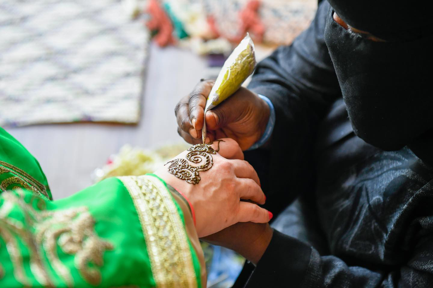 امرأة تقوم بنقش الحناء على الكف
